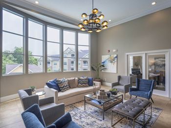 A living room with a large window and a view of houses outside.